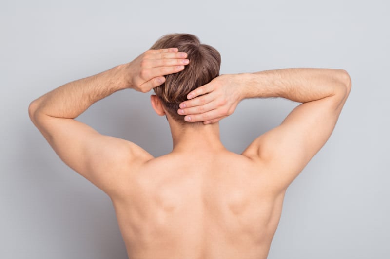 Backside photo of young man on grey color background