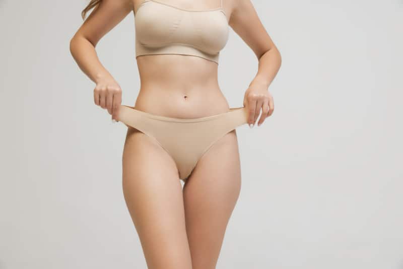 Cropped image of slim female body in cotton underwear