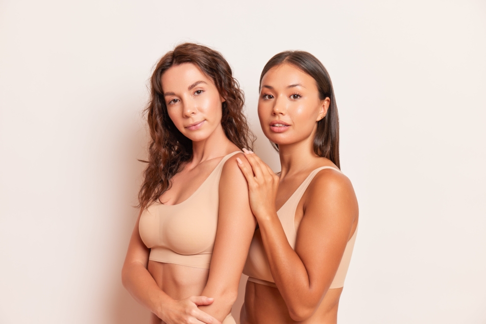 two girls smiling in nude sports bra