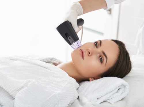 Woman receiving an RF lifting from a cosmetologist morpheus8